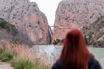Fototapeta premium woman observes mini waterfall between two mountains
