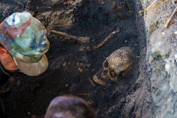 Human skull in the ground. Archaeological excavations of criminologists for examination. Background