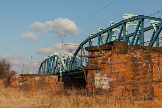 Blue railway bridge over the river Oder, Scinawa, Poland.  Bright cloudy sky industrial landscape.