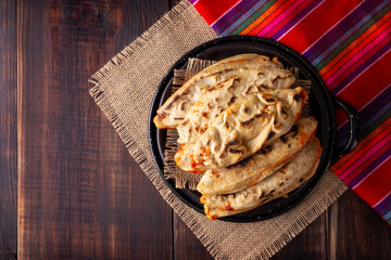Tlacoyos. Mexican pre hispanic dish made of corn flour patty filled with chicharron prensado (pressed pork rinds). Popular street food in Mexico.