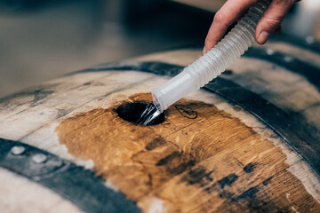 filling American oak barrel with new make, white dog whiskey, moonshine to age in Bourbon Whiskey...