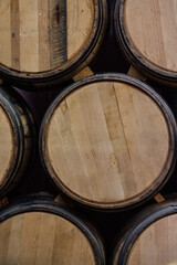 unlabeled American oak whiskey barrels stacked on each other using wooden wedge in distillery rackhouse warehouse