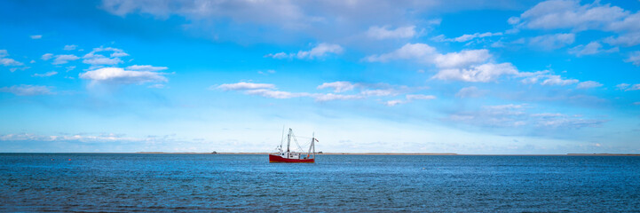 A fishing ship at the sea on the horizon