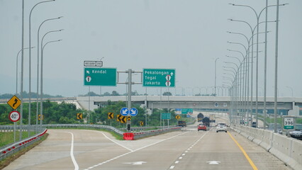 Trans Java toll road. There are signs for the city of Kendal, Jakarta, Pekalongan, Tegal