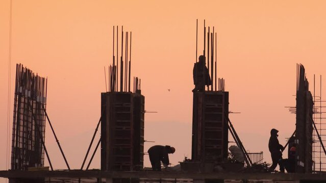Time-lapse video of the work of a team of installers at a construction site, filming at sunset