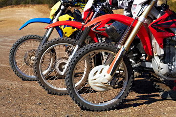 Fototapeta na wymiar Built for tough terrain. Three dirt bikes standing in a row.