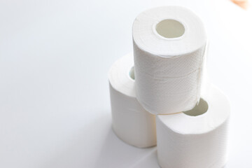 白いテーブルに積まれた三つのトイレットペーパー