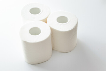 白い机の上に三つのトイレットペーパー