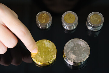 Close-up of finger touching golden bitcoin coin