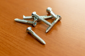 木製の作業台に置かれた金属のネジ