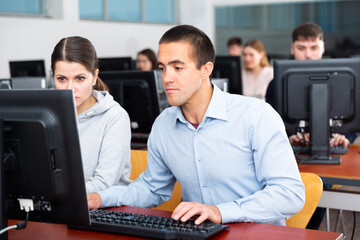 Man and woman study together in university computer class. High quality photo