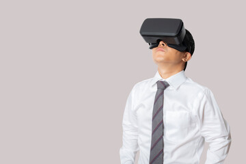 Studio portrait man wearing VR Headset isolated on gray background.