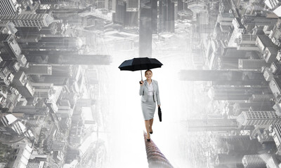 Businesswoman running with umbrella . Mixed media