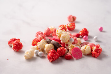 Colorful red and pink candied popcorn with mixed candies pile