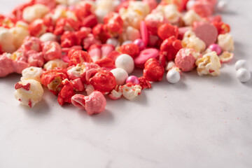 Colorful red and pink candied popcorn with mixed candies pile
