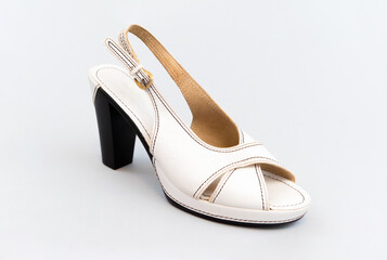 Fototapeta premium White vintage high-heeled sandals. isolated. Light gray background.