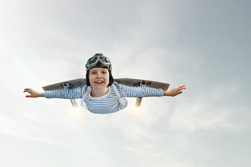 Happy little boy flying wearing helmet