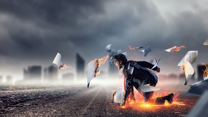Determined businessman leaving fire trails on asphalt