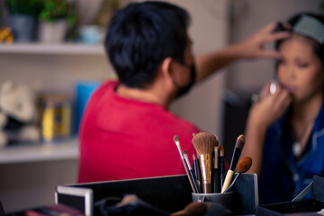 selective focus Make-up converter on makeup artist's table with lots of makeup artist tools. blur background makeup artist doing makeup beautiful girl There is space for text.