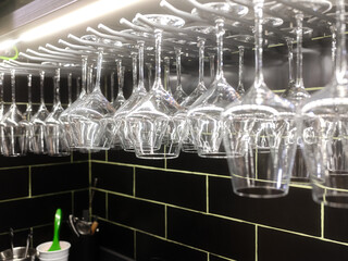 Wine glasses hanging from a rack in a restaurant