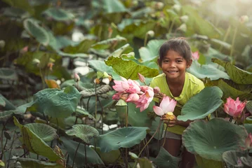 Foto op Aluminium A girl with a perfect smile holding a lotus flower and looking at the camera. Portrait of a young girl smiling happily. © somchai20162516