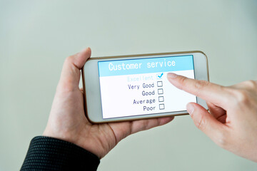 Hand holding smartphone with customer service survey form on screen