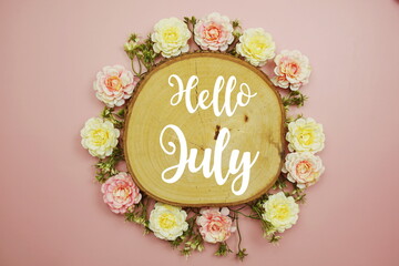 Hello July typography text decorate with flower on pink background