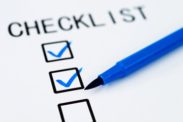 Checklist with checkmark and pen on paper