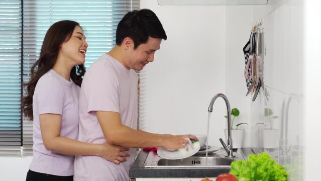 young couple with preparing vegetables to cooking together in the kitchen at home. woman is hugging man