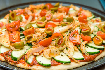Home-baked vegetarian pizza is being prepared before going into the oven