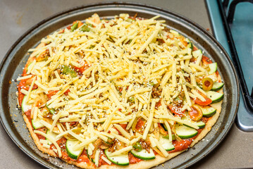 Home-baked vegetarian pizza is being prepared before going into the oven