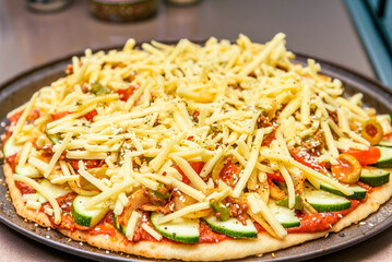 Home-baked vegetarian pizza is being prepared before going into the oven