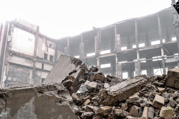 Ruins of large concrete fragments close-up on the background of the frame of a destroyed building...