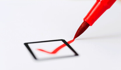 Red pen making a tick in check box