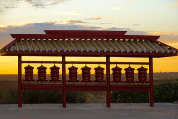 Buddhist prayer drums close-up at sunset. The Buddhist temple of Syakyusn-Syume. The neighborhood...