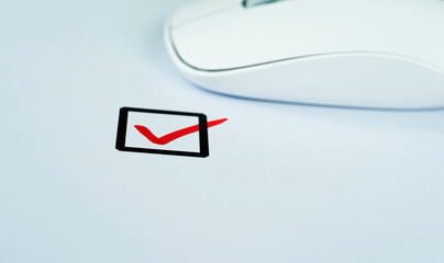 Computer mouse and check mark on paper
