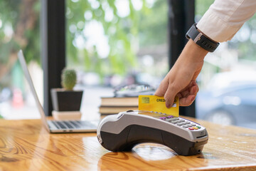 A businesswoman uses a credit card to swipe into a card swipe machine to pay for products and press...