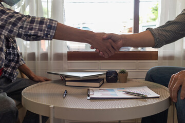 Smooth Focus, The young businessman is talking to an advisor to understand his new investment and handshake with an advisor to congratulate his adviser on making the business a success.