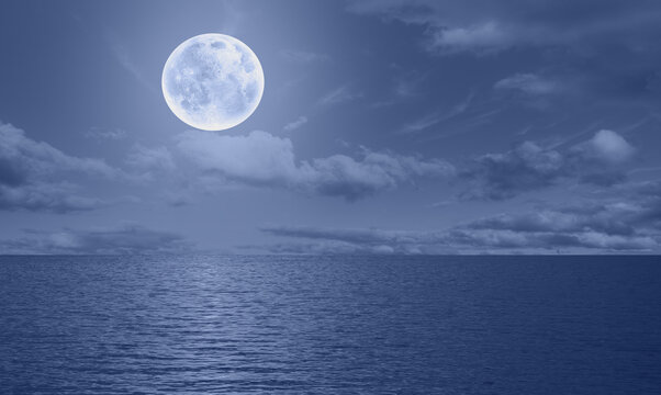 Moon rise in the clouds over the sea at night  "Elements of this image furnished by NASA