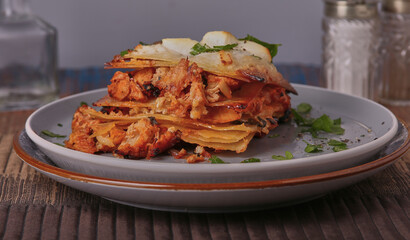 Spicy chicken lasagne garnished with herbs.