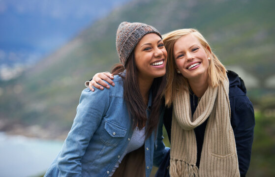 Warming up the day with friendship and laughter. Two happy young women smiling on the beach.
