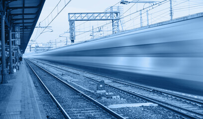 White high speed train runs on rail tracks -Train in motion