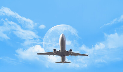 Fototapeta na wymiar White passenger airplane in the clouds with full moon - Travel by air transport 