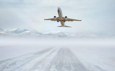 Fototapeta na wymiar Passenger airplane fly up over take-off runway - Snow-covered airport