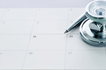 Stethoscope and pen over calendar - Powered by Adobe