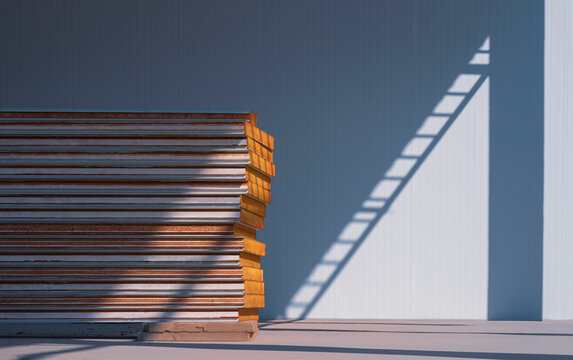 Stack of sandwich panels on the floor with sunlight and shadow on surface of cold storage room in freezer warehouse industry area