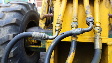 Old hydraulic hose fittings. Hydraulic system coupling connecting torn hoses of heavy equipment in...