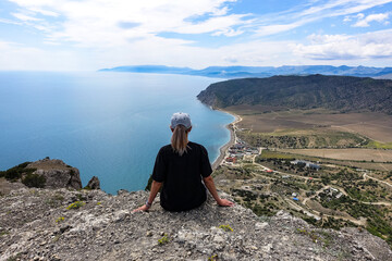 A girl on the background of landscapes of the Black Sea and the Crimean mountains on the Golitsyn trail. Crimea. 2021