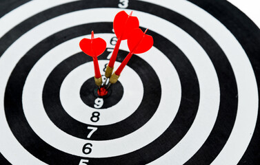 Three red dart arrows hitting in the target center