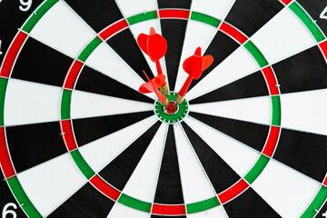 Three red dart arrows hitting in the target center
